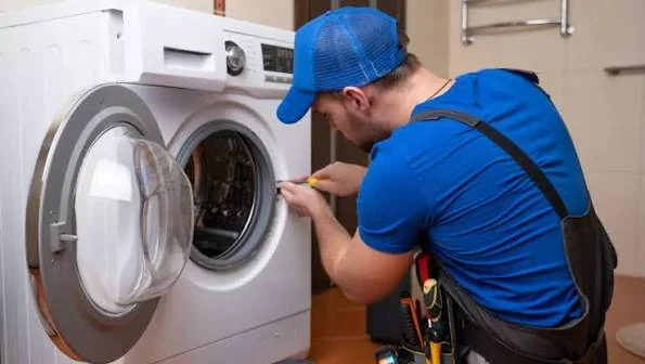 Technician inspecting the drum of a front-loading washing machine